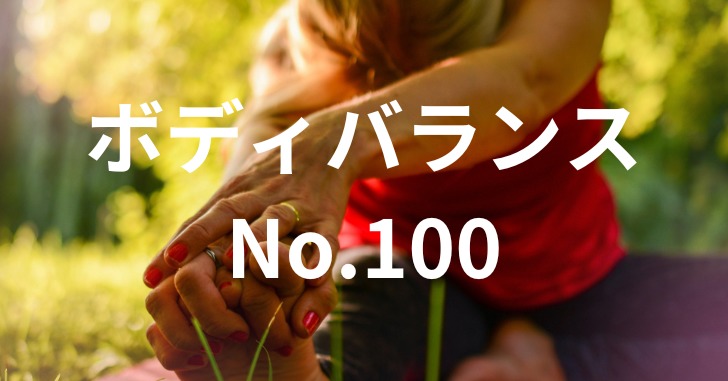 草がある場所で赤い服を着た女性がストレッチをしている